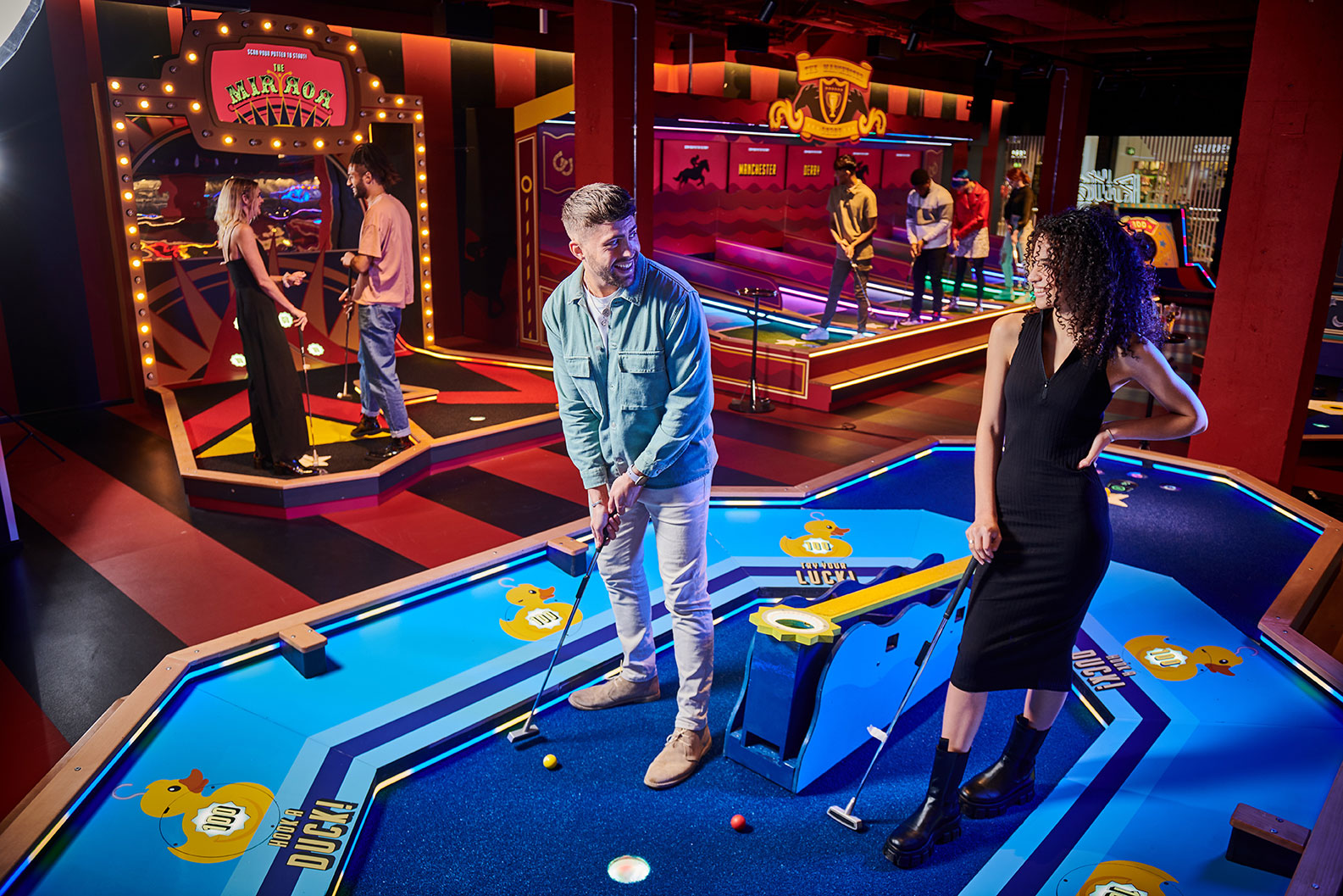 Couple playing on date night playing mini golf in Manchester.